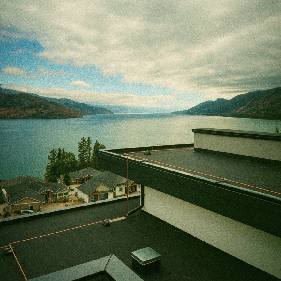 Copper wildfire sprinkler supply pipe running along a flat roof overlooking Okanagan Lake